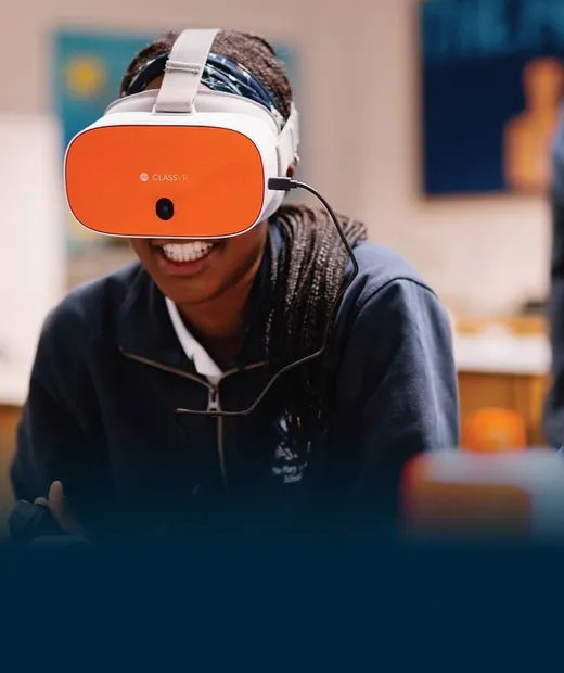 Estudiante utilizando un visor ClassVR junto a una docente en el aula.