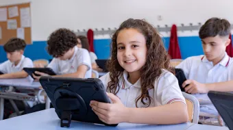 Estudiantes trabajando con tablets en el aula.